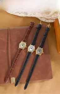 Orologio tonneau dorato vintage con quadrante romano su sfondo in pelle testurizzata