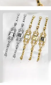 Detailed view of square dial quartz watches with elegant bangle bracelets on silk