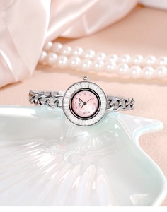 Detail of luxury silver bangle watch with pink mother of pearl dial and zircon bezel