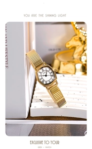 Retro tonneau gold watch for women with Roman numerals on a luxury display stand
