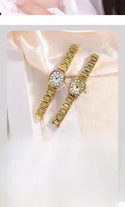 Close-up of GEDI octagonal gold watches with Roman numerals on elegant silk fabric