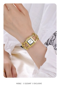 Close-up of golden square watch with chain strap worn on a woman wrist with white shirt