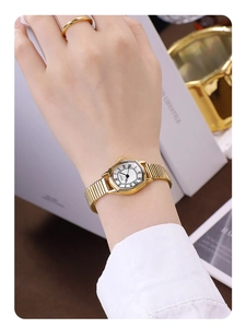 Detailed shot of retro gold tonneau watch with roman numerals on a female wrist