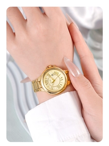Close-up of gold quartz watch with Roman numerals and date window on a wrist