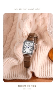 Detail of square vintage watch with brown leather strap on soft pink knitted fabric