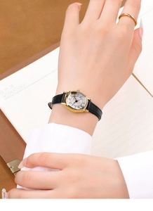 Macro dell'orologio GEDI vintage tonneau dorato con numeri romani e cinturino in pelle nera