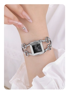 Close-up of GEDI silver bracelet watch with square black dial worn by female model