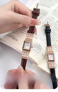 Détail d'une montre à quartz vintage carrée avec perles et bracelet en cuir marron