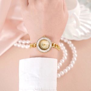 Montre GEDI dorée de luxe pour femme avec lunette en cristal et cadran blanc au poignet