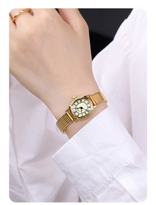 Detail of GEDI gold tonneau quartz watch with expandable band and Roman numerals on wrist