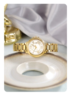 Detail of elegant gold-tone ladies watch featuring a Roman numeral dial and date window