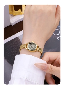 Close-up of GEDI vintage golden tonneau watch with Roman numerals on a female wrist