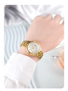 Detail of gold women's watch with white Roman dial and date window on a model's wrist