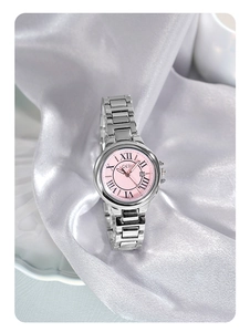 Close-up of pink dial luxury steel watch with Roman numerals and calendar window