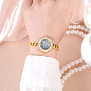 Montre à quartz luxe dorée pour femme avec cadran nacré et lunette en cristal