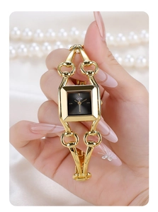 Detail of elegant gold bracelet watch featuring a square black dial on silk background