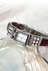 Gros plan détaillé d'une montre à quartz carrée argentée avec perles et bracelet en cuir
