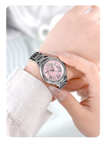 Macro detail of silver stainless steel watch with pink Roman dial and date window