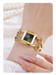 Close-up of GEDI vintage square watch with black dial and golden link bracelet on wrist