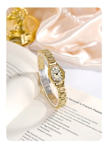 Elegant gold tonneau watch on silk fabric with pearls and vintage decor accents