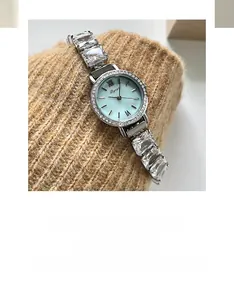 Detail of light blue sunray dial watch with rhinestone bezel and crystal strap link