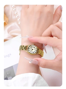Close-up of GEDI gold tonneau watch with Roman numerals on a silk and pearl background
