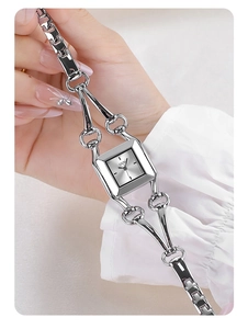 Close-up of silver square quartz watch with stylish cutout H-link metal bracelet band
