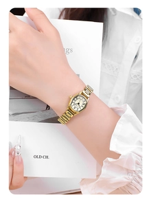 Detail of vintage tonneau-shaped gold watch with Roman numerals on a female wrist