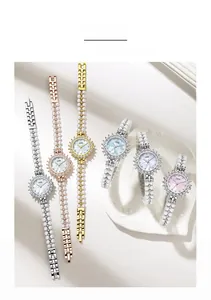 Flat lay of elegant women's watches with pearl bracelets and shimmering crystal bezels
