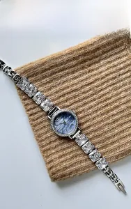 Detail of luxury watch with deep blue textured dial and square crystal link bracelet