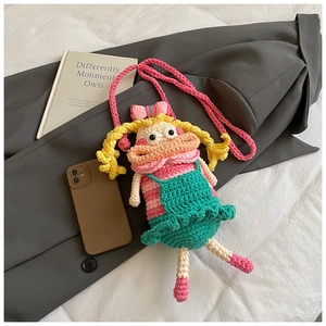 Close-up of handmade crochet cartoon doll crossbody bag with vibrant yarn textures