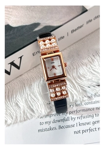 Détail d'une montre vintage carrée avec perles et bracelet en cuir noir