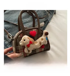 Gros plan du mini sac à carreaux rétro avec décoration chiot en peluche et anses en cuir