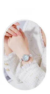 Detail of luxury mother of pearl watch with pearl bracelet strap on a female wrist