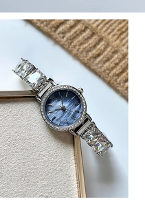 Detail of luxury women's watch with blue dial, crystal band and diamond-set bezel