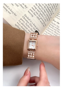 Détail d'une montre à quartz carrée avec bracelet en perles et boîtier en or rose