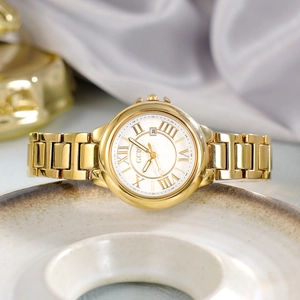 Luxury gold women's quartz watch with white Roman dial and date window on silk backdrop