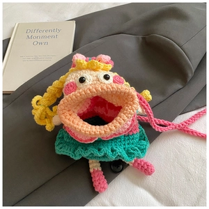 Détail d'un sac bandoulière fait main au crochet avec visage cartoon et tresses jaunes