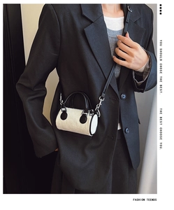 Gros plan d'un mini sac seau en velours côtelé porté avec un blazer noir élégant