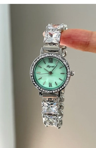 Close-up of a women quartz watch featuring light green dial and crystal link bracelet