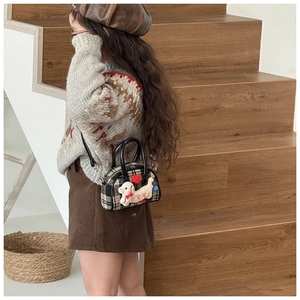 Detailed close-up of a plaid children's handbag with a cute 3D plush puppy applique