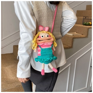 Détail d'un sac bandoulière fait main au crochet avec motif de fille et tricot coloré