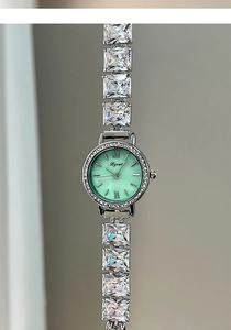 Detail of silver quartz watch with light green mother-of-pearl dial and zircon strap