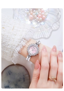 Detail of luxury women's watch with pink rose dial, crystal bezel and pearl bracelet band