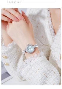 Elegant pearl bracelet watch with floral pattern dial on a female model's wrist