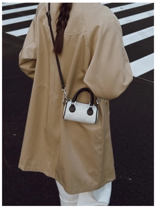 Mini sac seau en velours côtelé avec poignées en cuir porté par un mannequin