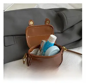 Detail view of the retro brown mini bag interior showing capacity for cosmetics and accessories