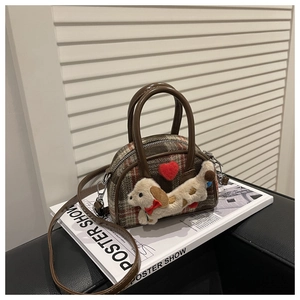 Detailed view of kids plaid mini handbag with plush dog charm and red heart accent