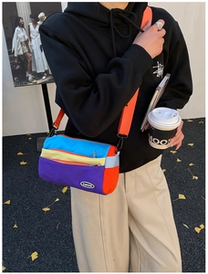 Detailansicht der bunten Nylon-Zylindertasche mit Mode-Logo und verstellbarem Riemen