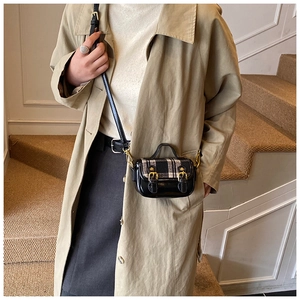 Detail of mini plaid bowling bag with black patent leather and gold metal buckles